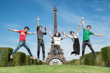Estudiantes Internacionales en Francia, saltando de felicidad frente a la Torre Eiffel